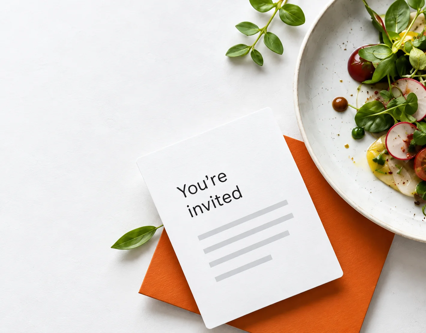 An invitation card with orange envelope, herbs and a restaurant dish